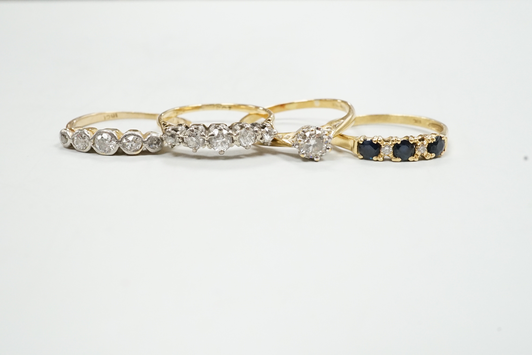 Three assorted modern 18ct and diamond set rings including solitaire size M and an 18k, sapphire and diamond chip ring, gross weight 8.1 grams.